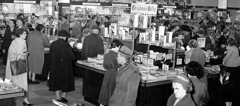 Customers browse the displays of Christmas Books and Gifts in 1953. The customers are all smartly dressed with many wearing hats and raincoats. (Image with special thanks to Reg and Ray Gallanders)